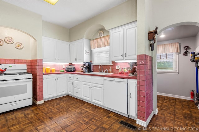 kitchen featuring white appliances, white cabinets, dark parquet flooring, sink, and tasteful backsplash