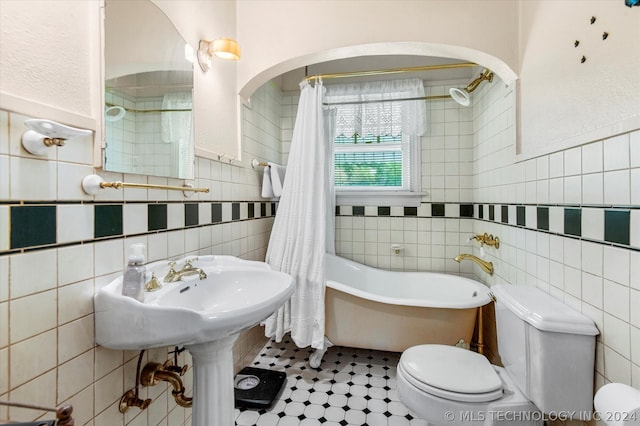 bathroom with tile floors, tasteful backsplash, toilet, and tile walls