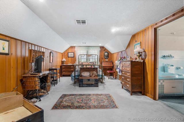 carpeted bedroom with wood walls, a textured ceiling, and lofted ceiling