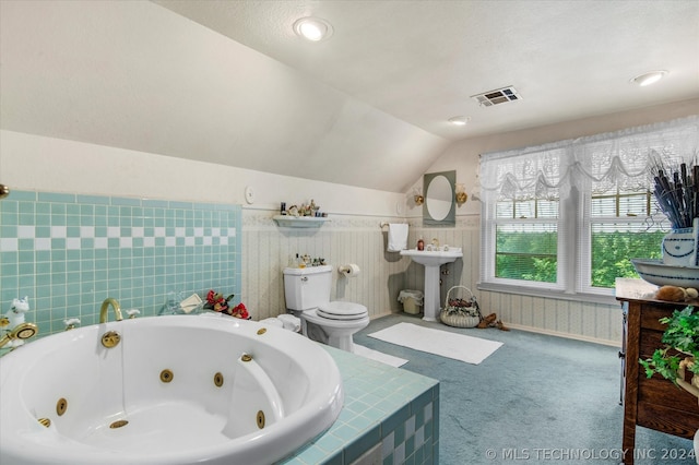 bathroom featuring tile walls, sink, lofted ceiling, and toilet