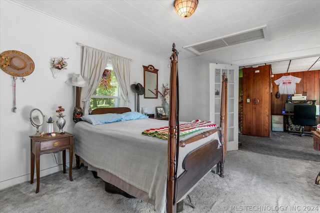 carpeted bedroom with wooden walls