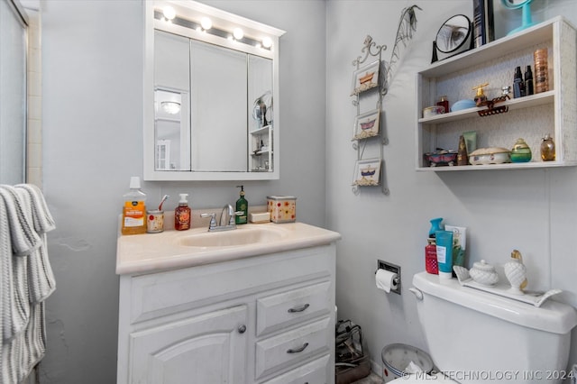 bathroom featuring vanity with extensive cabinet space and toilet