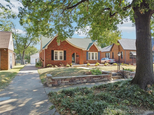 view of front of home with a front yard, an outdoor structure, and a garage