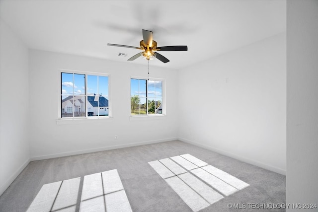 carpeted spare room featuring ceiling fan