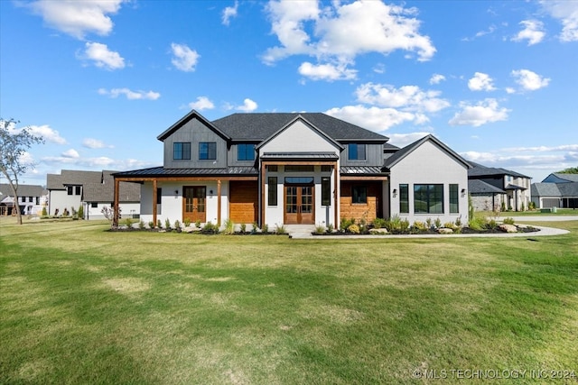 modern inspired farmhouse with board and batten siding, a front yard, a standing seam roof, and metal roof