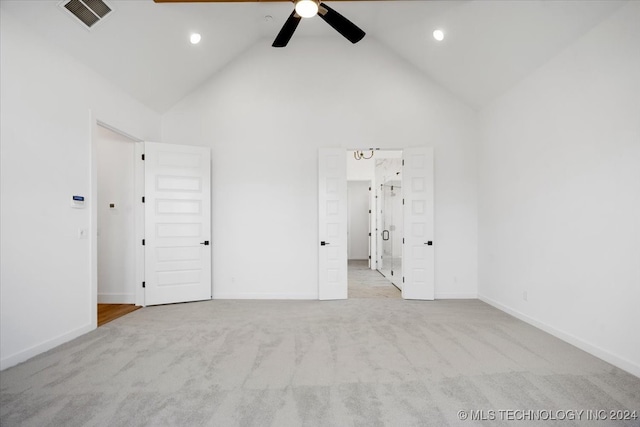 carpeted empty room featuring ceiling fan and high vaulted ceiling