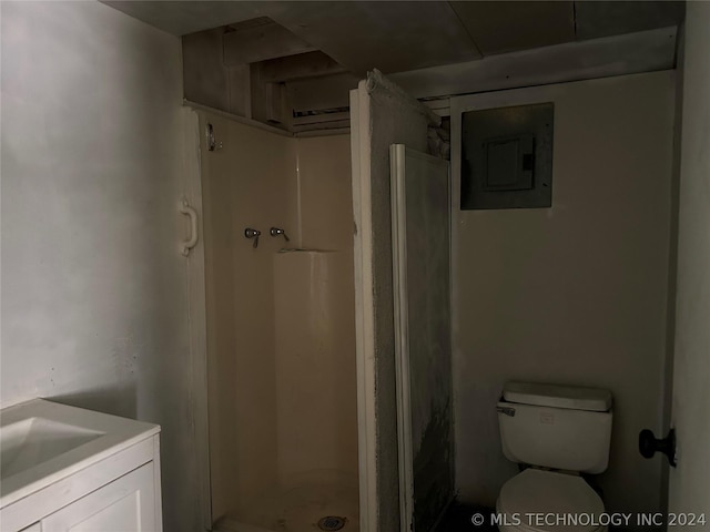 bathroom featuring a shower, electric panel, vanity, and toilet