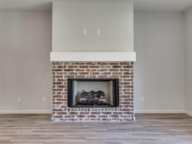 details with wood-type flooring and a brick fireplace