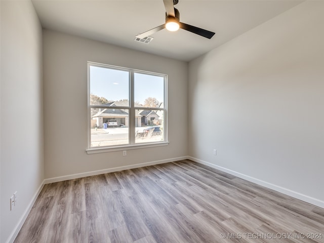 empty room with ceiling fan and light hardwood / wood-style flooring