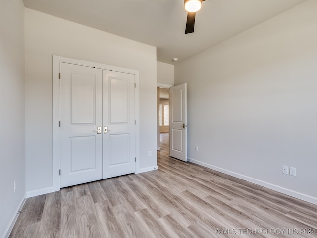 unfurnished bedroom featuring a closet, light hardwood / wood-style floors, and ceiling fan