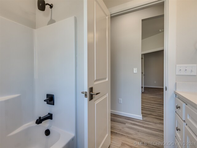 bathroom featuring vanity, shower / bathtub combination, and hardwood / wood-style flooring