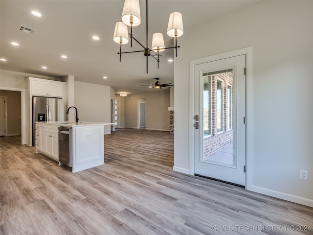 kitchen with ceiling fan, sink, white cabinets, and pendant lighting