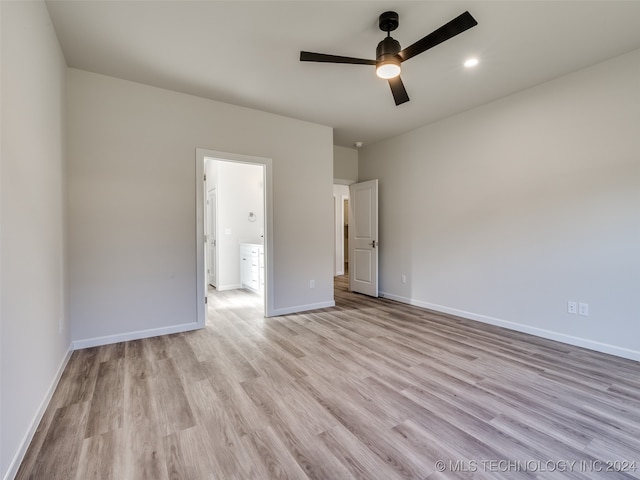 unfurnished bedroom with ceiling fan, light hardwood / wood-style floors, and connected bathroom