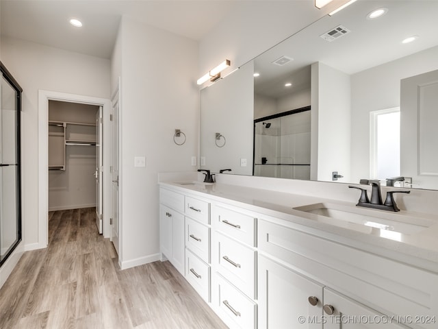 bathroom featuring vanity, wood-type flooring, and walk in shower