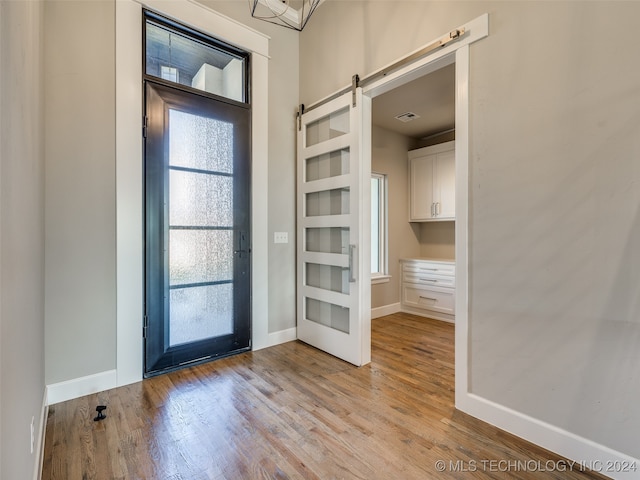 entryway featuring a barn door and light hardwood / wood-style floors