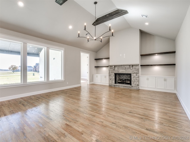 unfurnished living room with a chandelier, a fireplace, high vaulted ceiling, and light hardwood / wood-style floors