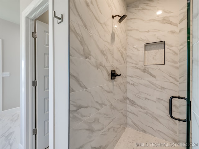 bathroom featuring a shower with shower door