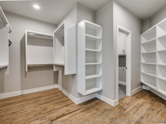 walk in closet with hardwood / wood-style flooring