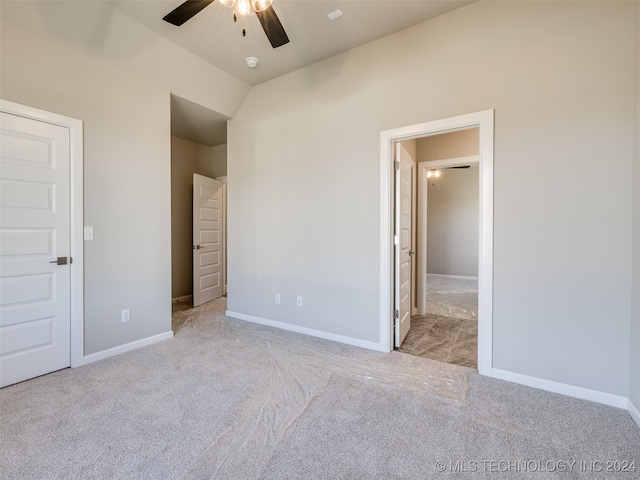 unfurnished bedroom featuring ceiling fan, lofted ceiling, and light carpet