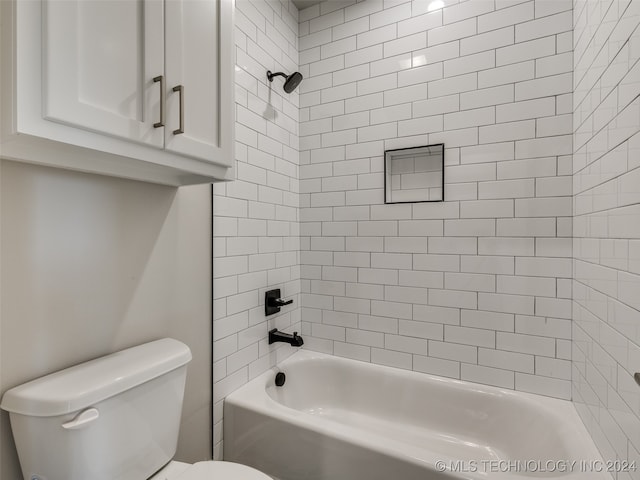 bathroom with toilet and tiled shower / bath