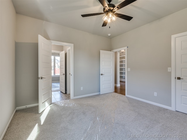 unfurnished bedroom with ceiling fan and light colored carpet