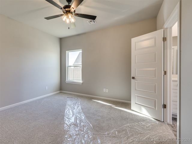 spare room featuring light colored carpet and ceiling fan