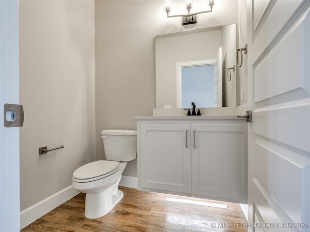 bathroom featuring hardwood / wood-style floors, vanity, and toilet