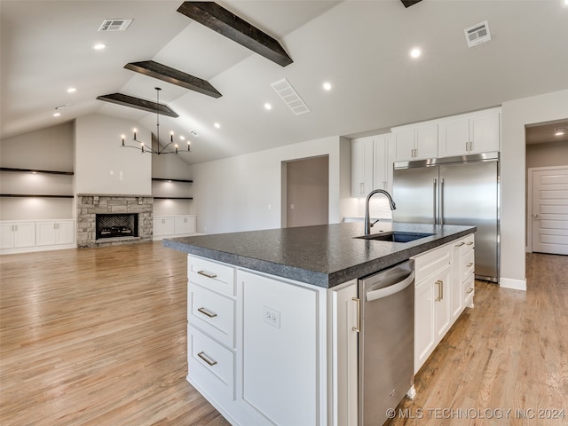 kitchen featuring sink, light hardwood / wood-style flooring, lofted ceiling with beams, a center island with sink, and white cabinets