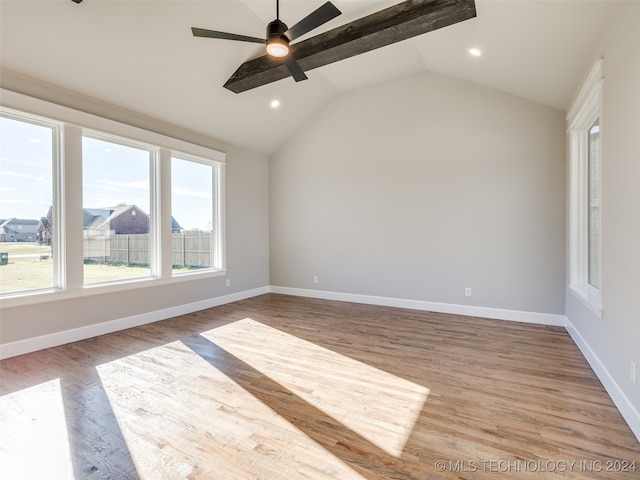 empty room featuring hardwood / wood-style floors, vaulted ceiling with beams, and ceiling fan