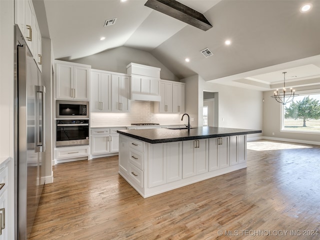 kitchen featuring sink, light hardwood / wood-style flooring, an island with sink, white cabinets, and appliances with stainless steel finishes