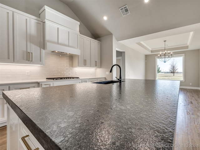 kitchen with sink, white cabinets, a spacious island, and light hardwood / wood-style flooring