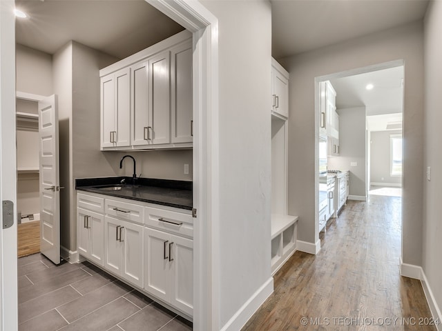 kitchen featuring hardwood / wood-style flooring, white cabinetry, and sink