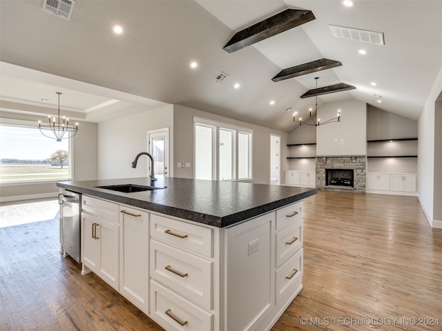 kitchen with a fireplace, sink, a center island with sink, white cabinets, and light hardwood / wood-style floors