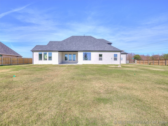 rear view of property with a lawn