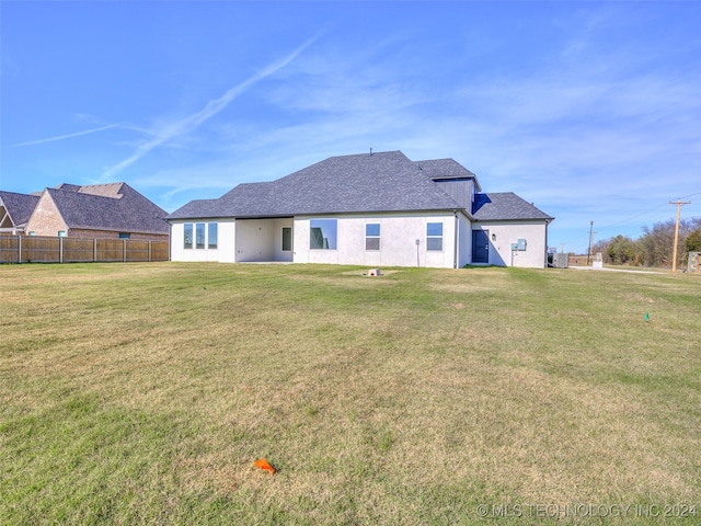 rear view of property featuring a lawn