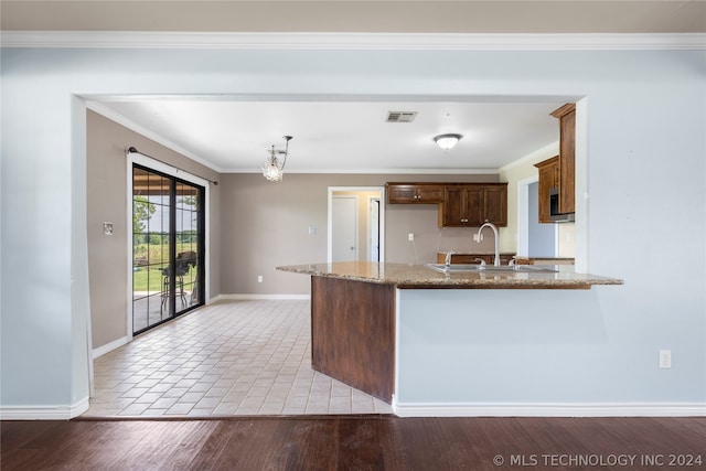 kitchen with crown molding, kitchen peninsula, and hardwood / wood-style floors