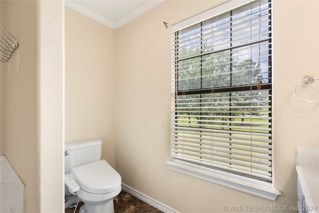 bathroom featuring tile floors, ornamental molding, and toilet