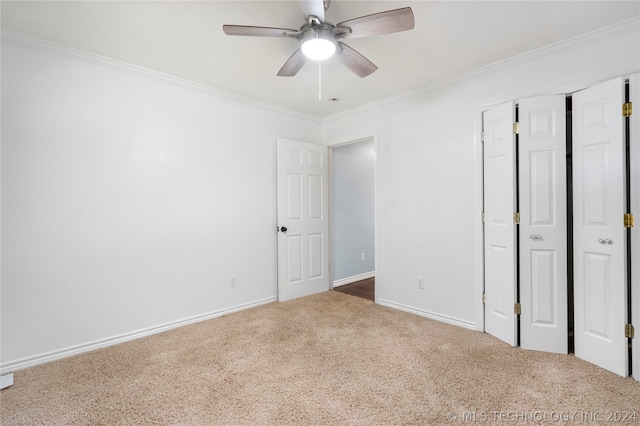 unfurnished bedroom with ceiling fan, carpet floors, and crown molding