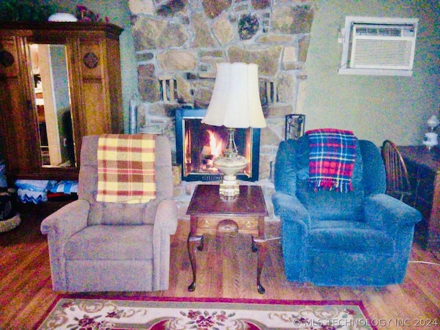 living room with a wall mounted AC and hardwood / wood-style flooring