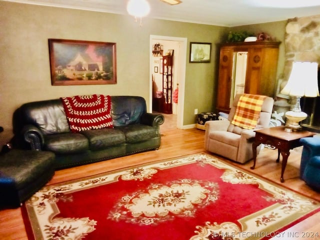 living room with hardwood / wood-style floors, ceiling fan, and crown molding