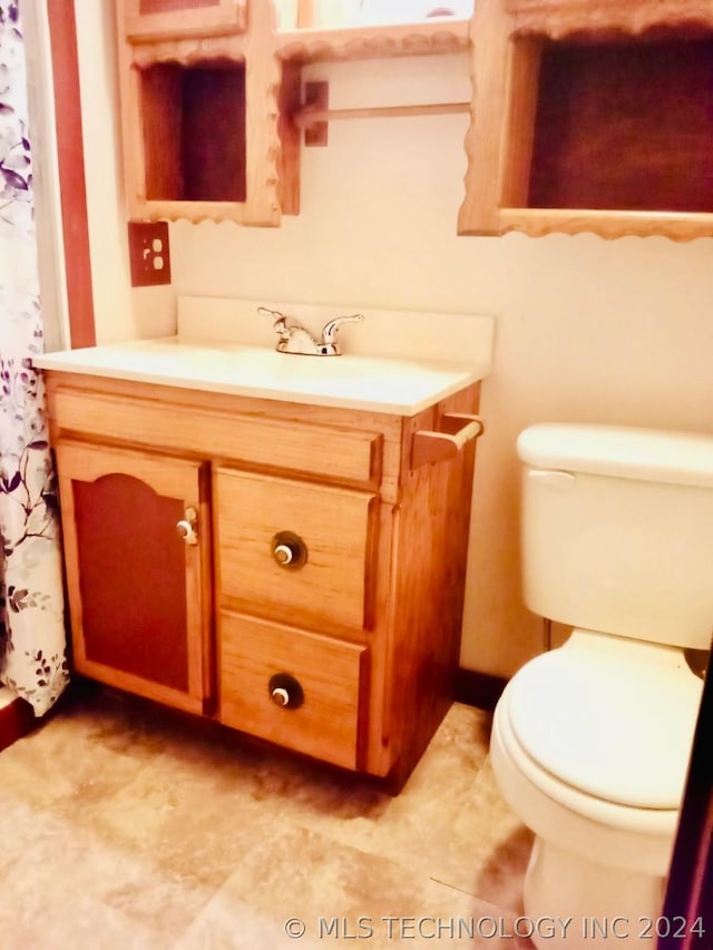 bathroom featuring vanity, toilet, and walk in shower