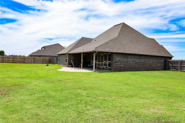 rear view of property with a patio and a lawn