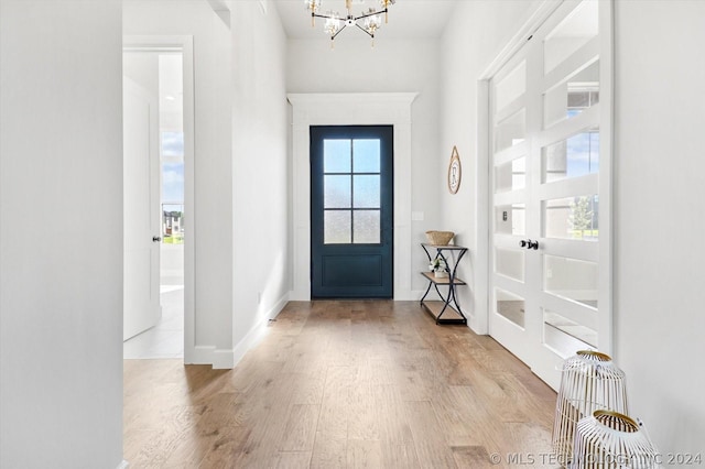 foyer entrance featuring an inviting chandelier and light wood-type flooring