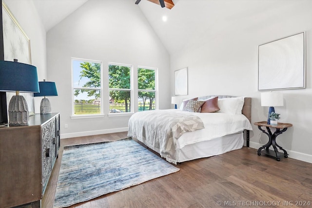 bedroom featuring ceiling fan, dark wood-type flooring, and high vaulted ceiling