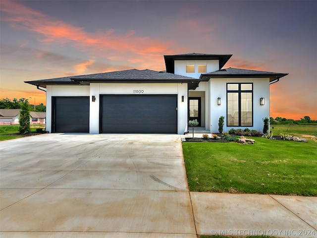 prairie-style house with a garage and a yard