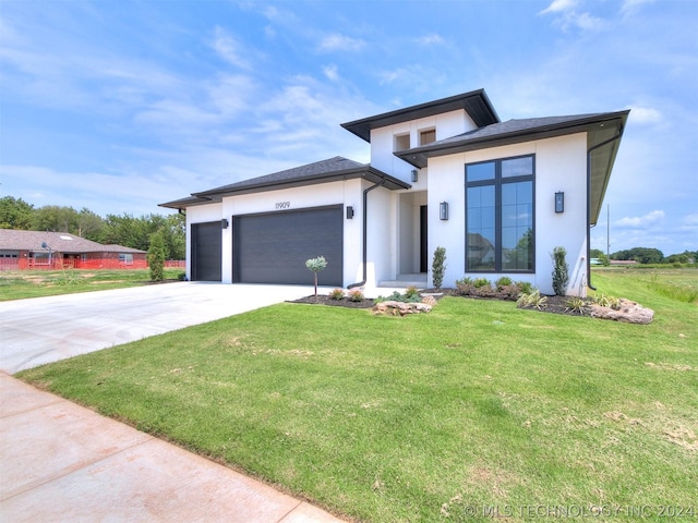 view of front of house featuring a garage and a front lawn