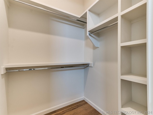 walk in closet with dark wood-type flooring