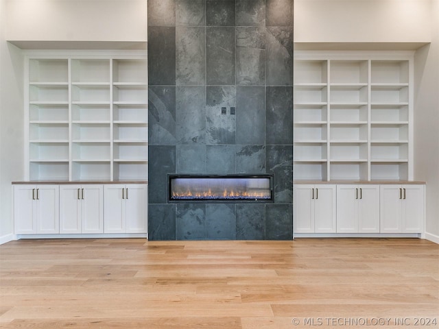 unfurnished living room with a fireplace and light hardwood / wood-style floors