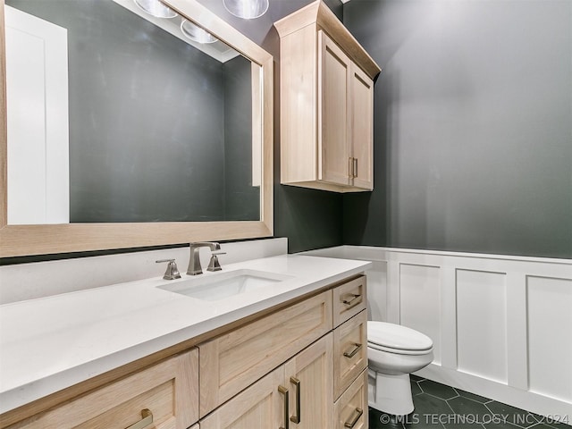 bathroom featuring tile patterned flooring, vanity, and toilet