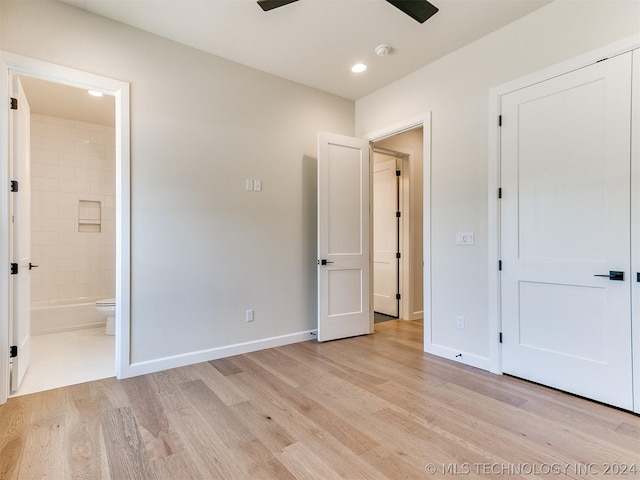 unfurnished bedroom featuring connected bathroom, ceiling fan, and light wood-type flooring